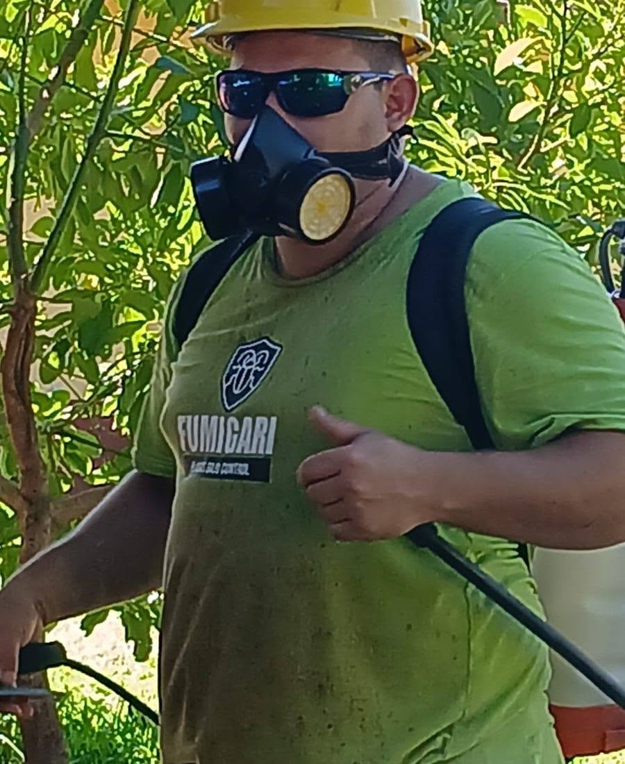 Técnico de Fumigari con mochila pulverizadora, casco y protección respiratoria