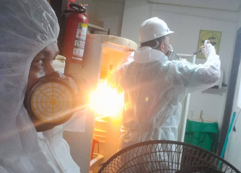 Equipo de Fumigari aplicando tratamiento con equipo de protección completo